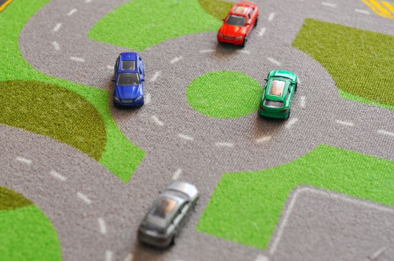 57637407 - toy cars over a carpet circuit