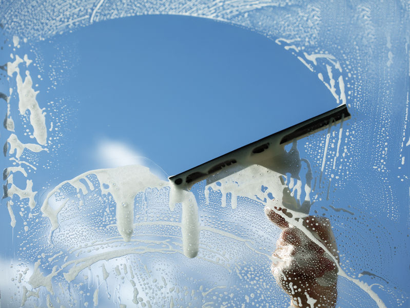 32147702 - window cleaner using a squeegee to wash a window